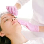 Woman receives cosmetic injection in clinical setting, enhancing beauty using modern techniques.