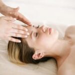A woman enjoying a relaxing face massage at a spa for therapeutic benefits.